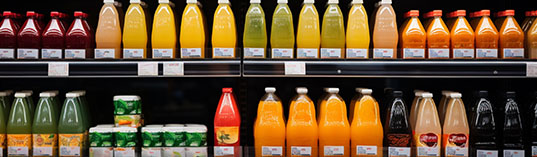 Fresh organic drinks, juices in a supermarket, Variety Shopping  in a supermarket apples, oranges, bananas, grapes, pineapples lemons, healthy consumerism food concept.