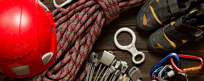 climbing and travel equipment on dark wooden background, top view. Insurance climbing equipment for safe climbing sportsmen