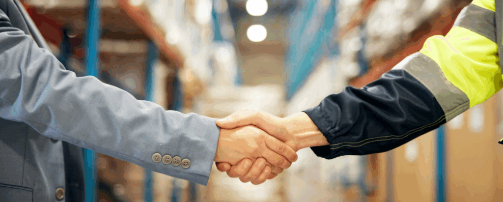 Two people shaking hands in a warehouse